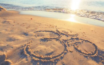 Om symbol in the sand at the beach